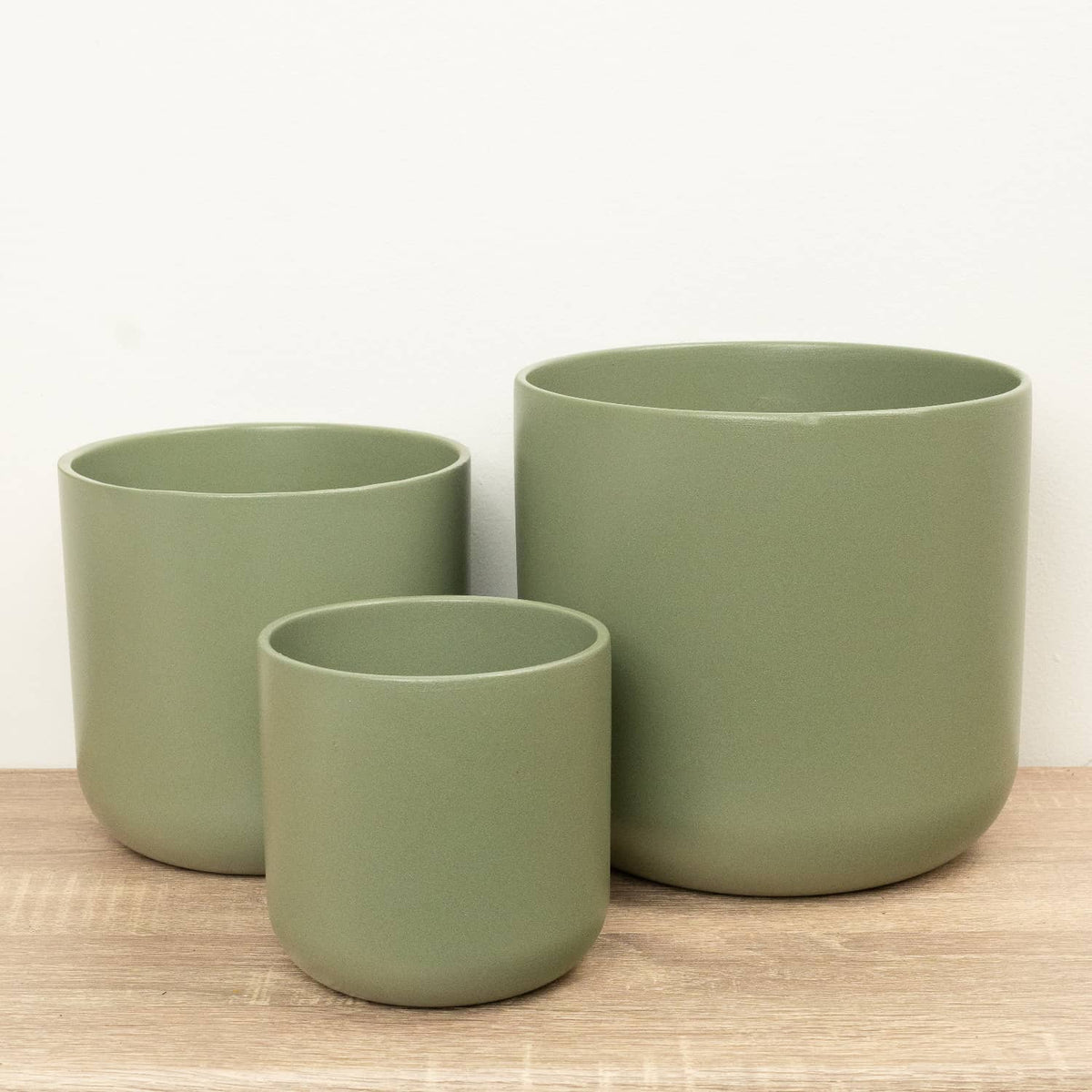 Three Sage Green Lisbon ceramic plant pots with curved profiles.